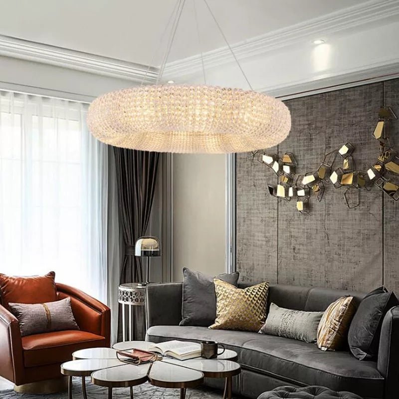 Luxury round crystal chandelier illuminating a modern living room interior.