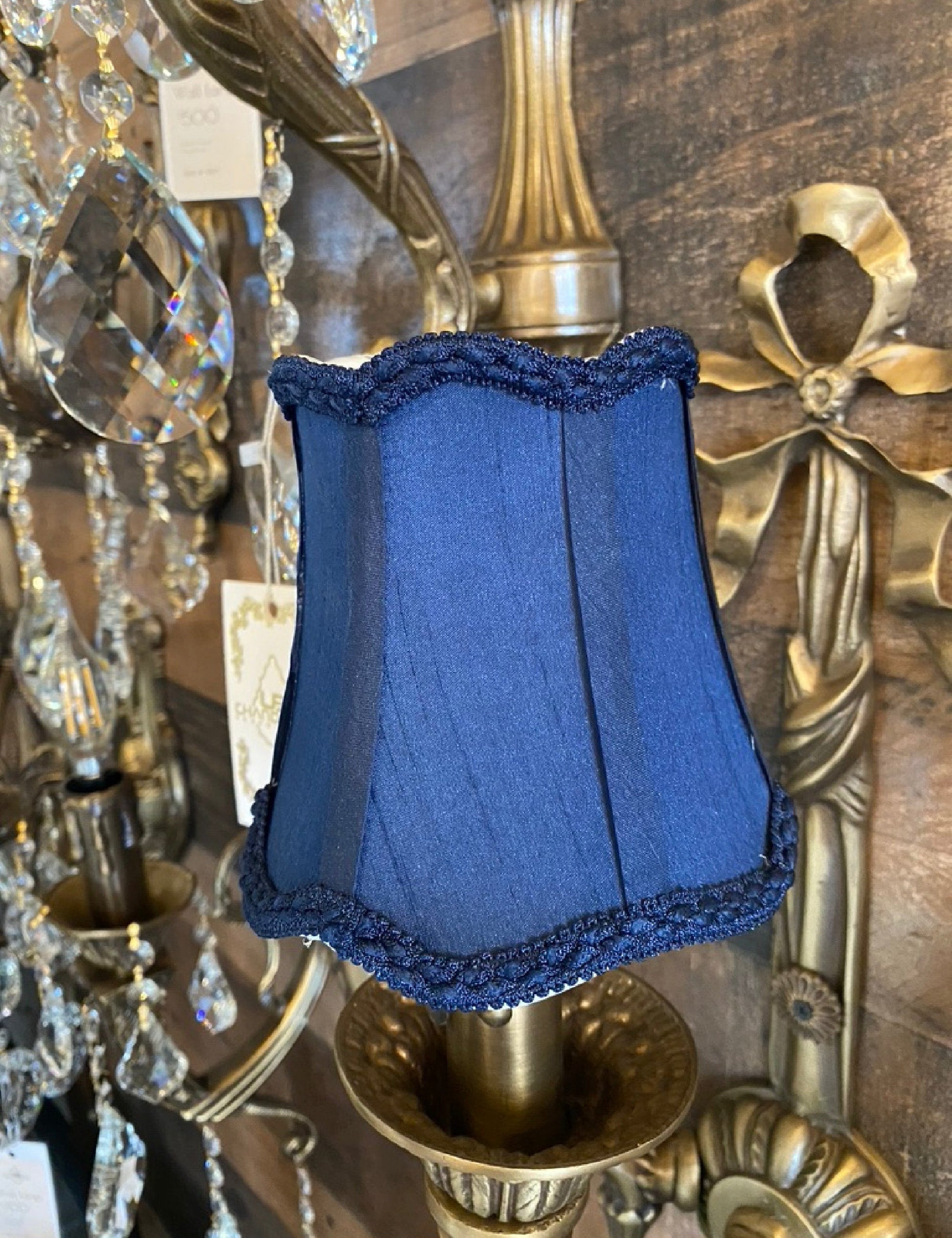 Navy blue fabric clip-on lamp shade installed on chandelier