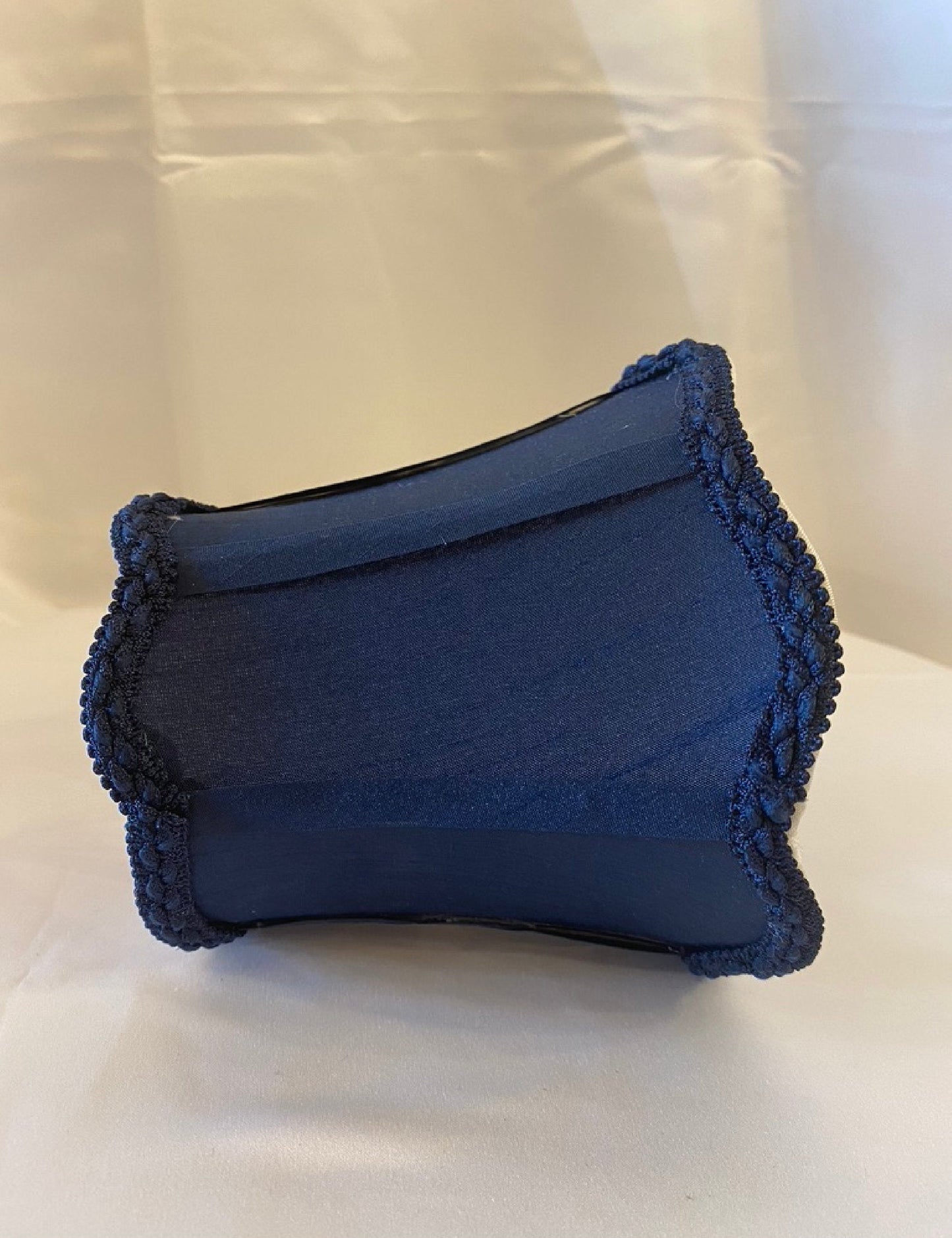 Side profile of navy blue fabric lamp shade with trim
