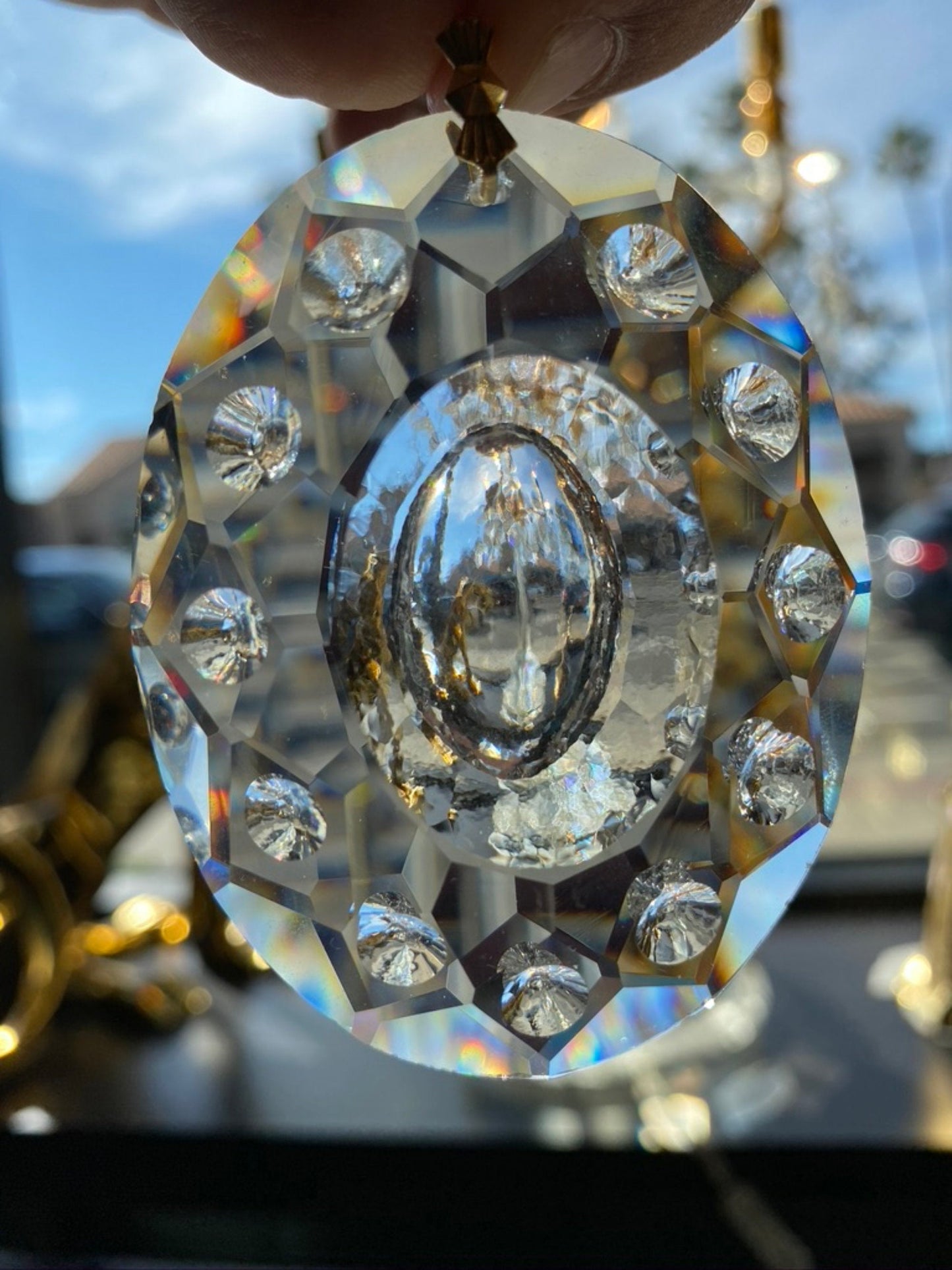 Faceted oval crystal pendant reflecting natural prismatic light